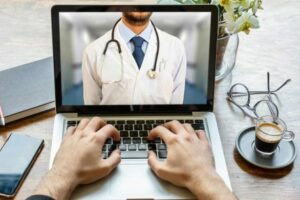 Telemedicine concept. Doctor GP on a computer screen, office desk background